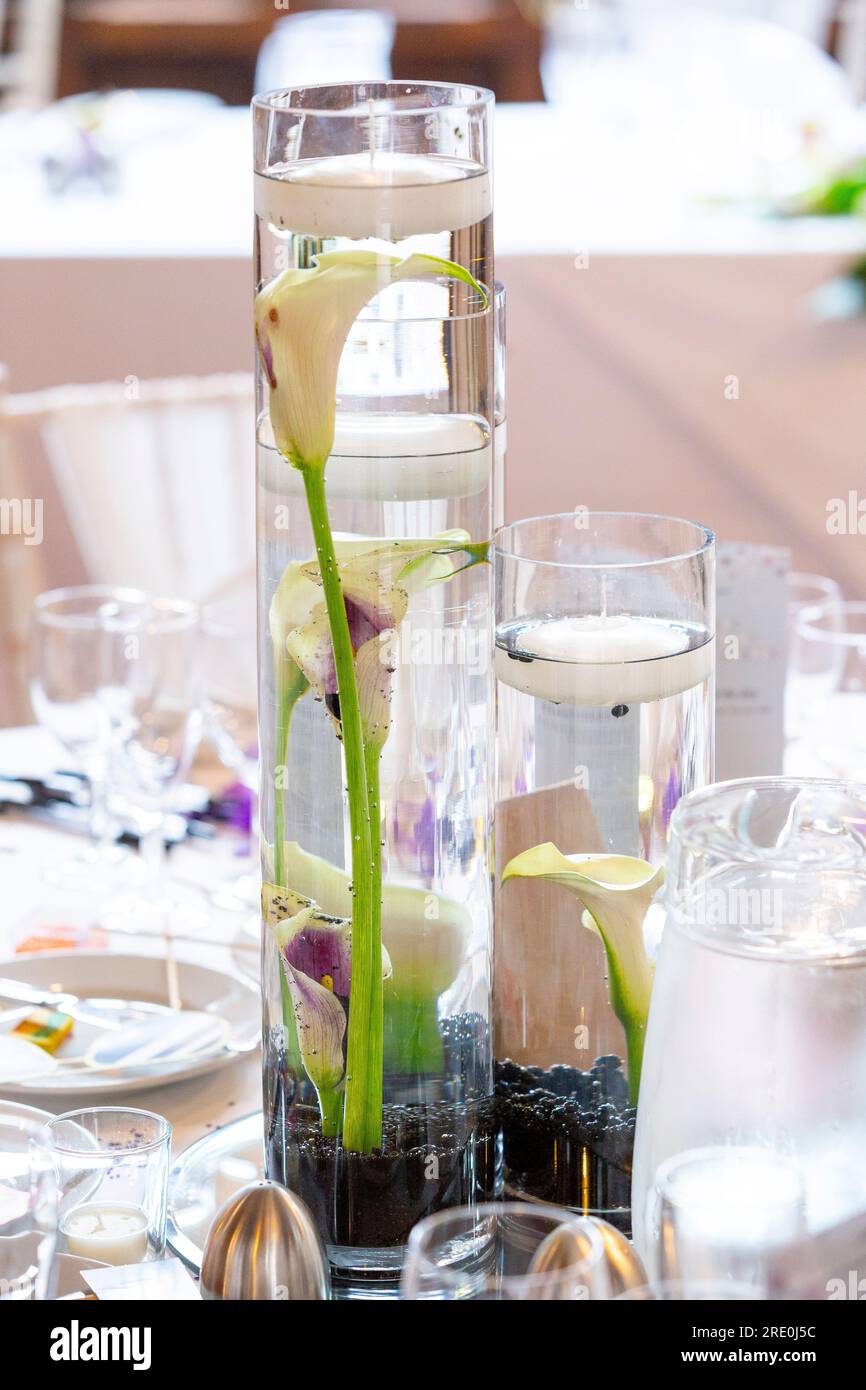 Wedding centrepiece featuring Calla lilies in tall glass jars with floating candles Stock Photo