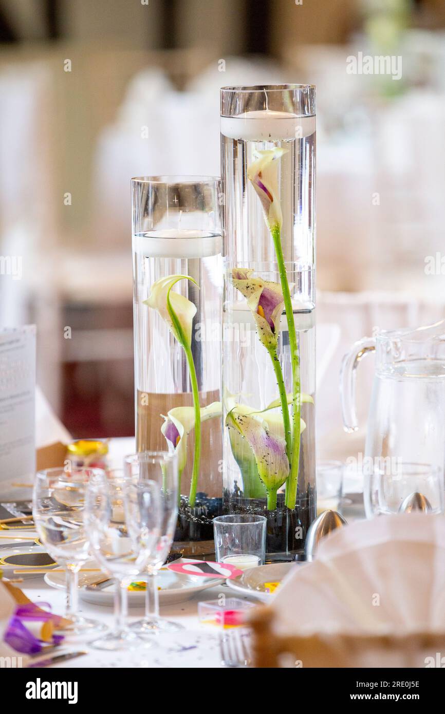 Wedding centrepiece featuring Calla lilies in tall glass jars with floating candles Stock Photo