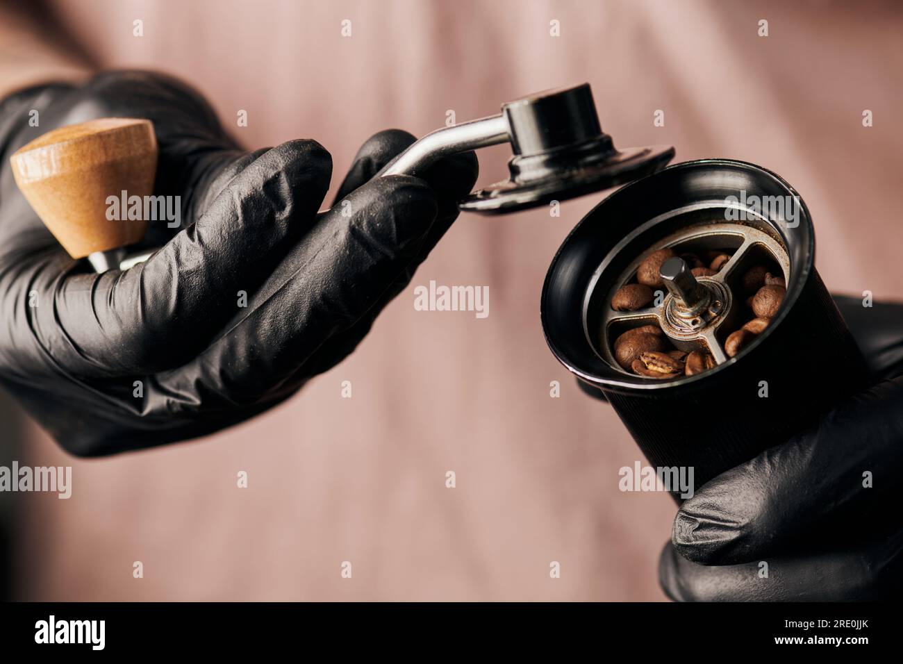 https://c8.alamy.com/comp/2RE0JJK/partial-view-of-barista-holding-manual-coffee-grinder-with-coffee-beans-arabica-drink-energy-2RE0JJK.jpg