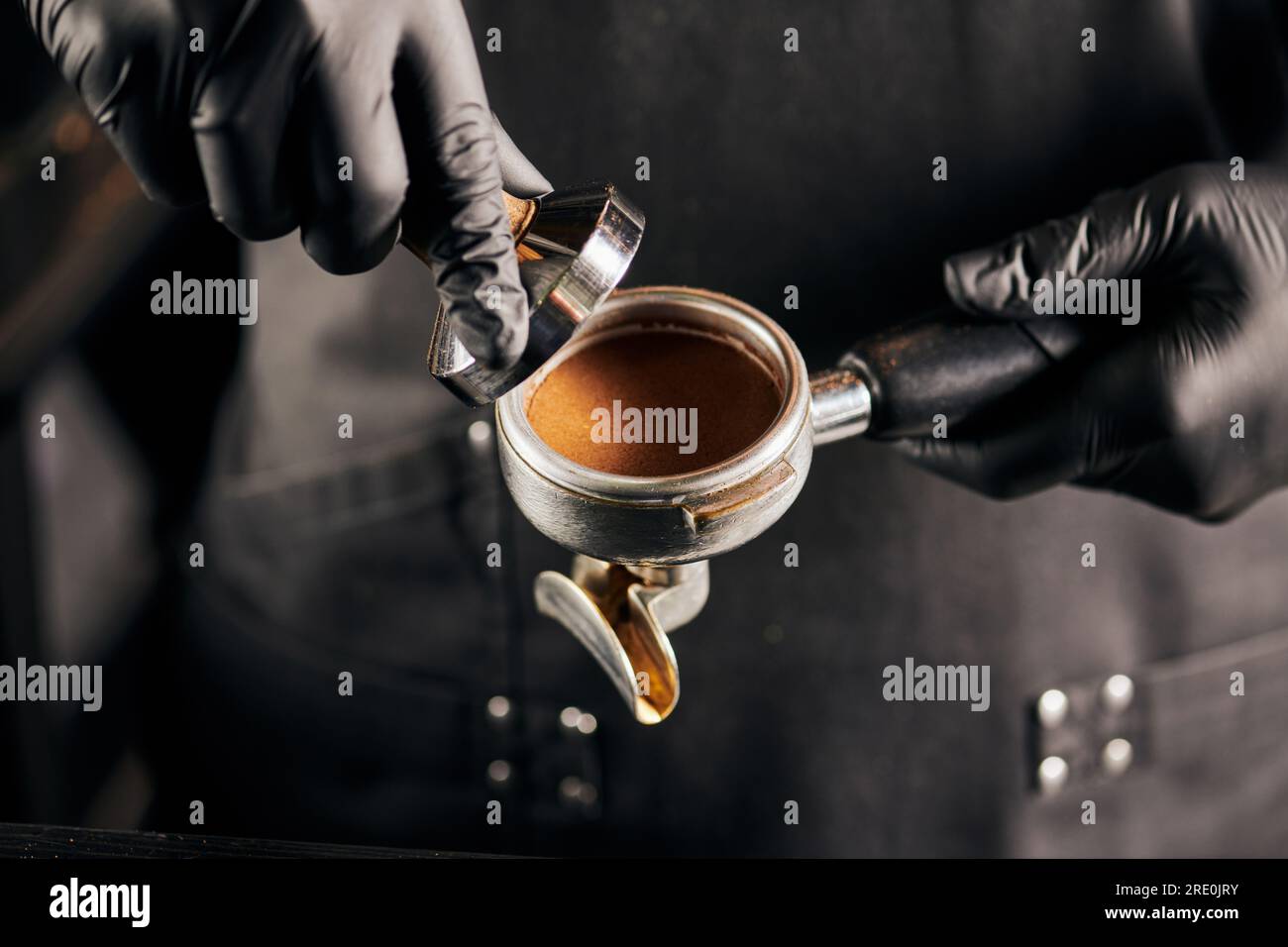 barista holding tamper near portafilter with grinded coffee, espresso, manual  press Stock Photo by LightFieldStudios