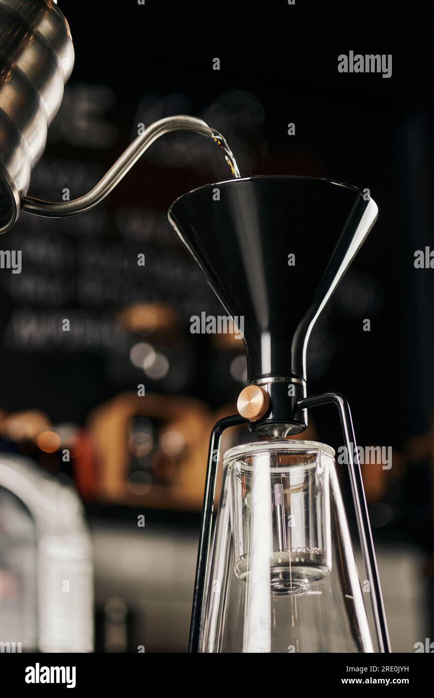 siphon coffee maker and boiling water pouring from drip kettle during preparation, pourover