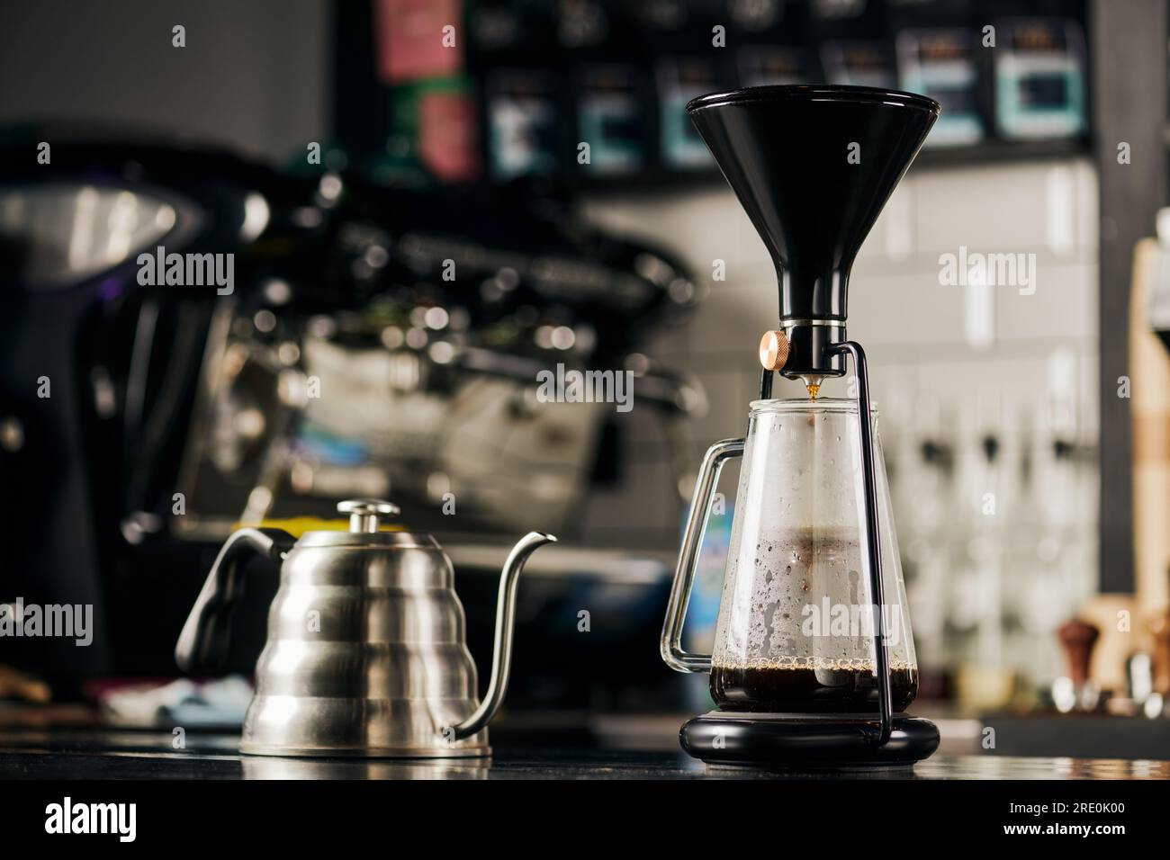 modern siphon coffee maker and metallic drip cattle for espresso preparation in modern cafe