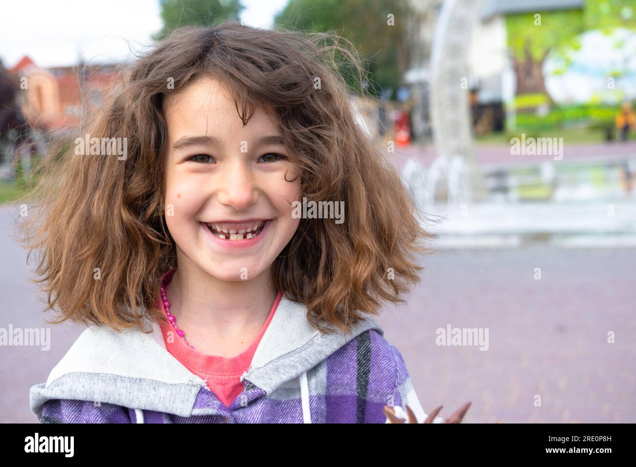 Toothless happy smile of a girl with a fallen lower milk tooth closeup