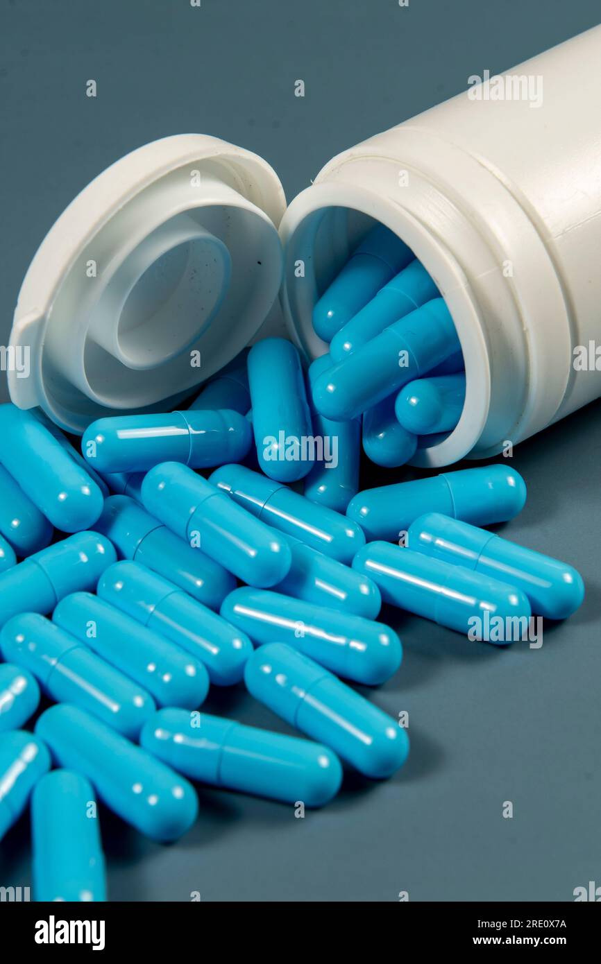 Gelatin pills sticking out of a white medicine bottle. Pharmaceutical