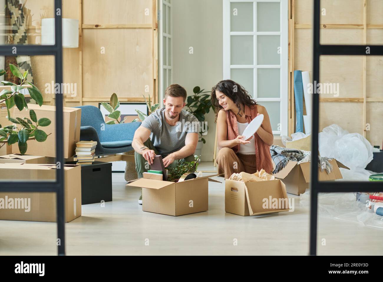Happy family unpacking cardboard boxes hi-res stock photography and ...