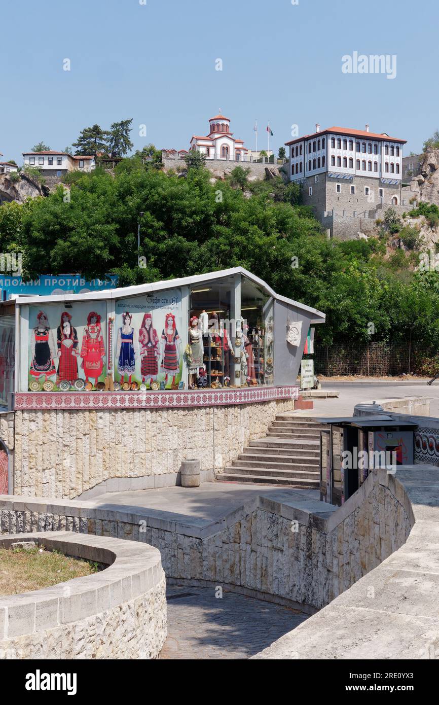 Plovdiv, Bulgaria. Subway entrance area and shop with illustrations f traditional clothing. Church in background on the hill. Stock Photo