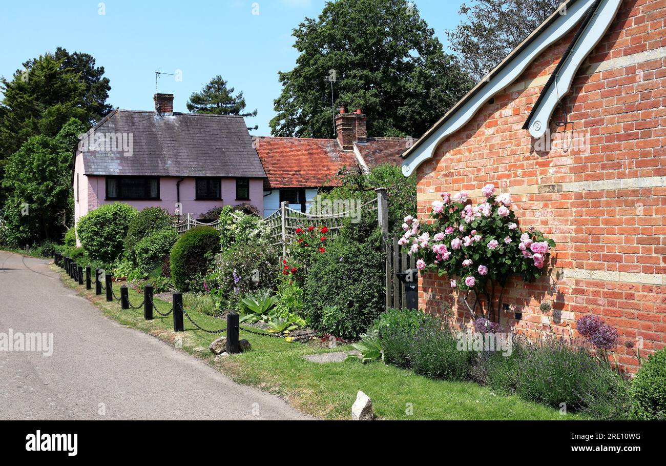 Quaint English Village street with pretty cottages and flowering rose bushes Stock Photo