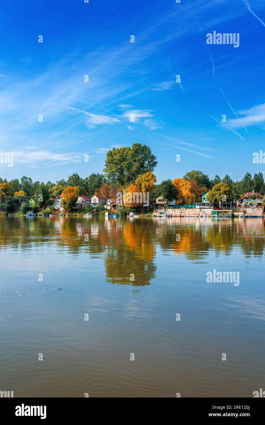 River Tisza and tiny houses at its riverbank in autumn. Beautiful seasonal landscape from Vojvodina, Serbia. Stock Photo
