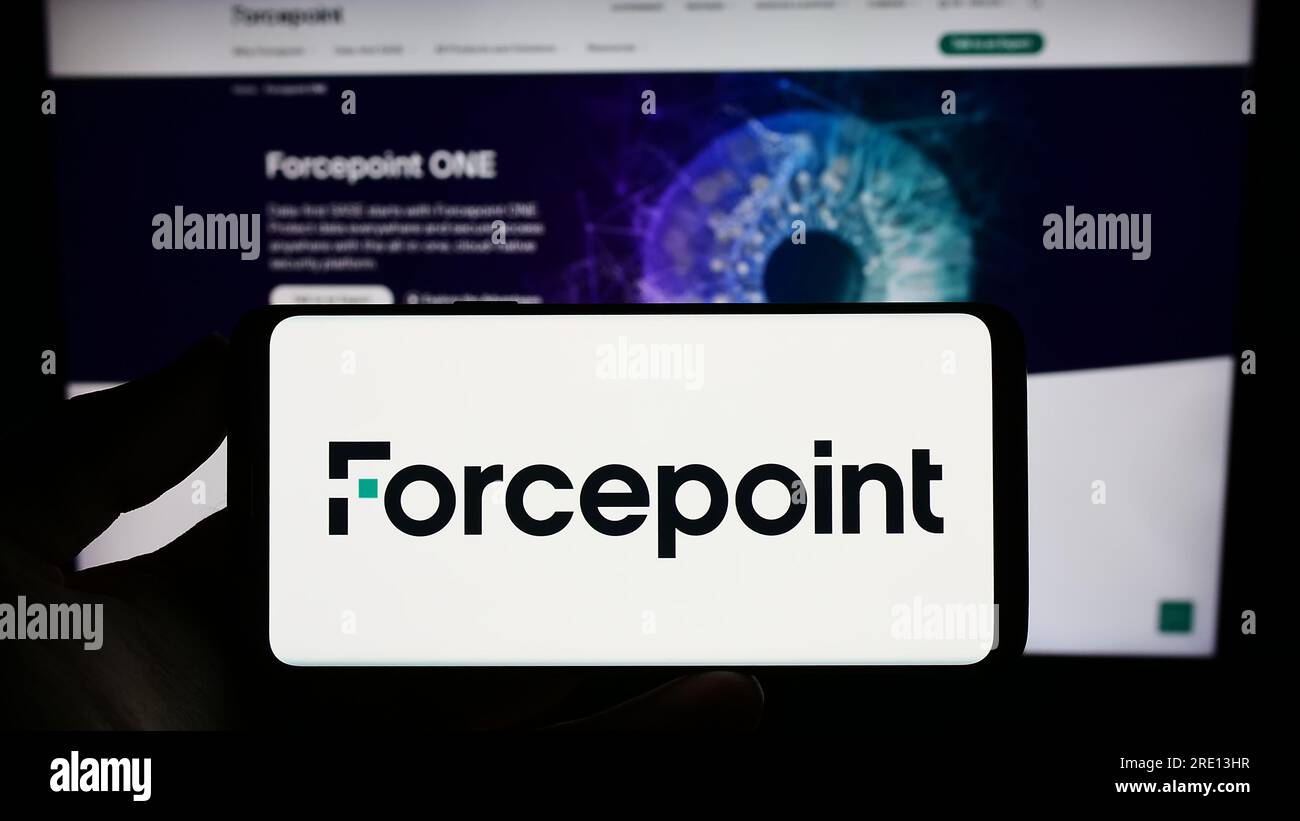 Person holding cellphone with logo of US cybersecurity company Forcepoint LLC on screen in front of business webpage. Focus on phone display. Stock Photo