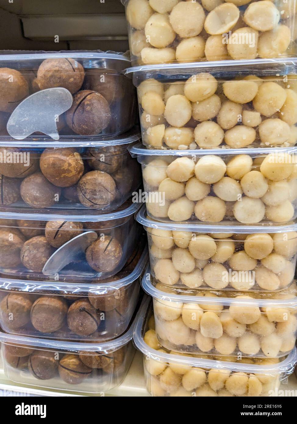 Macadamia nuts in the shell and without it in plastic containers in the