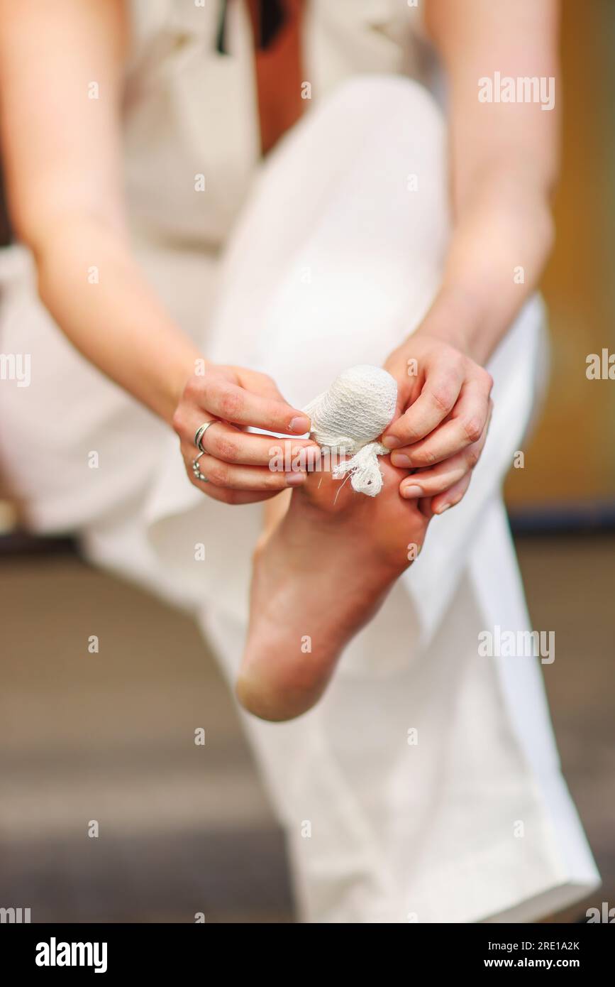 girl bandaging her toe outside Stock Photo Alamy