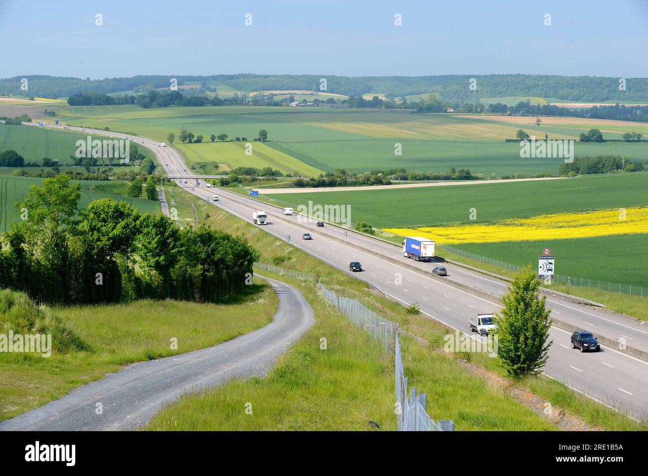 Highway A28 crossing the “pays de Bray” area. Motorway in the middle of wheat, barley, escurgeon and rapeseed fields. Access road to bordering fields, Stock Photo