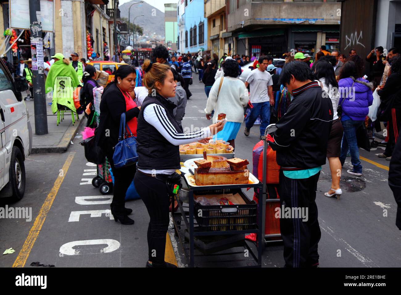 Woman selling crema volteada flan and other caramel desserts on street stall in commercial area of central Lima, Peru Stock Photo