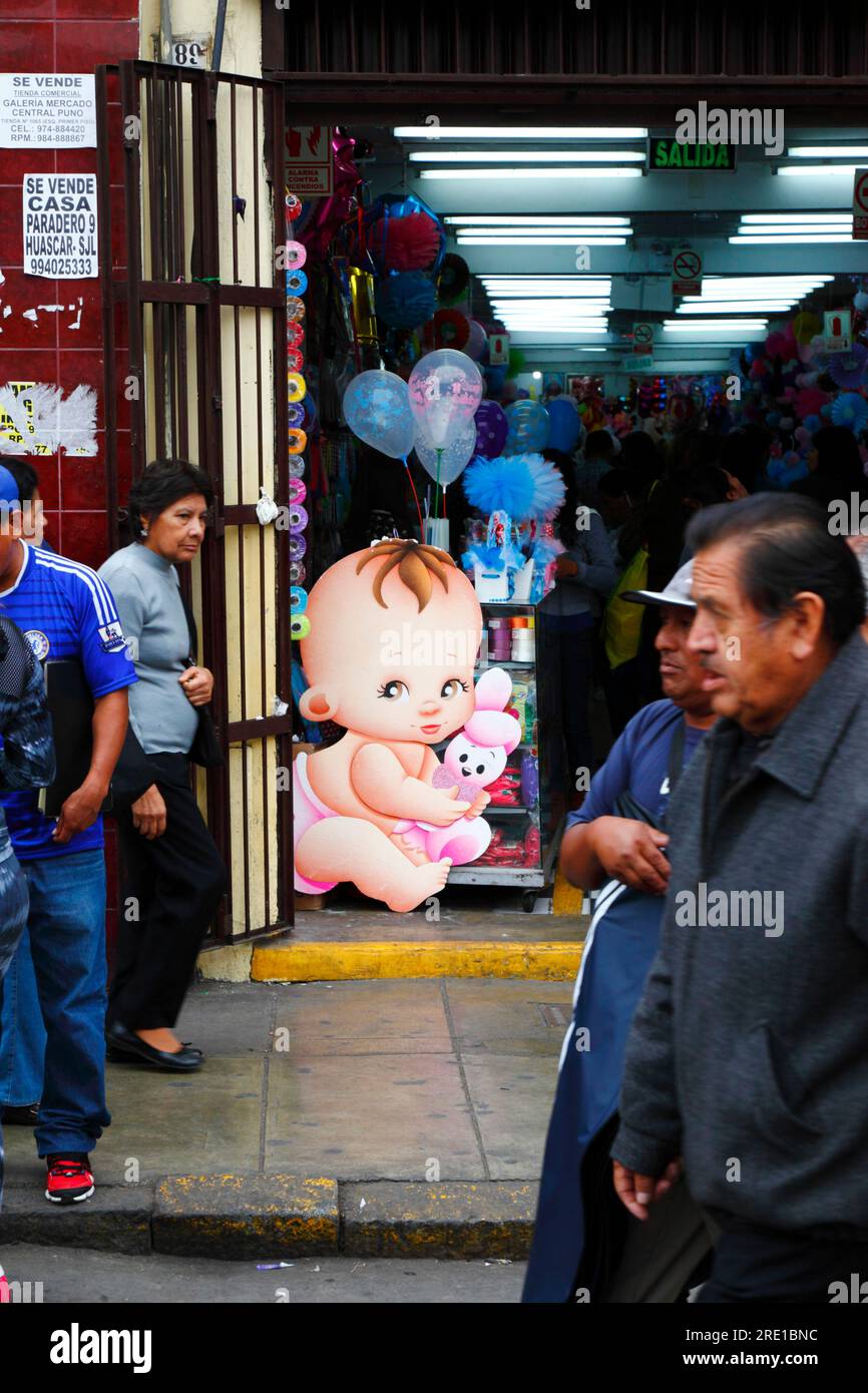 Large cardboard cutout baby in entrance of shop selling things for children in commercial area of central Lima, Peru Stock Photo