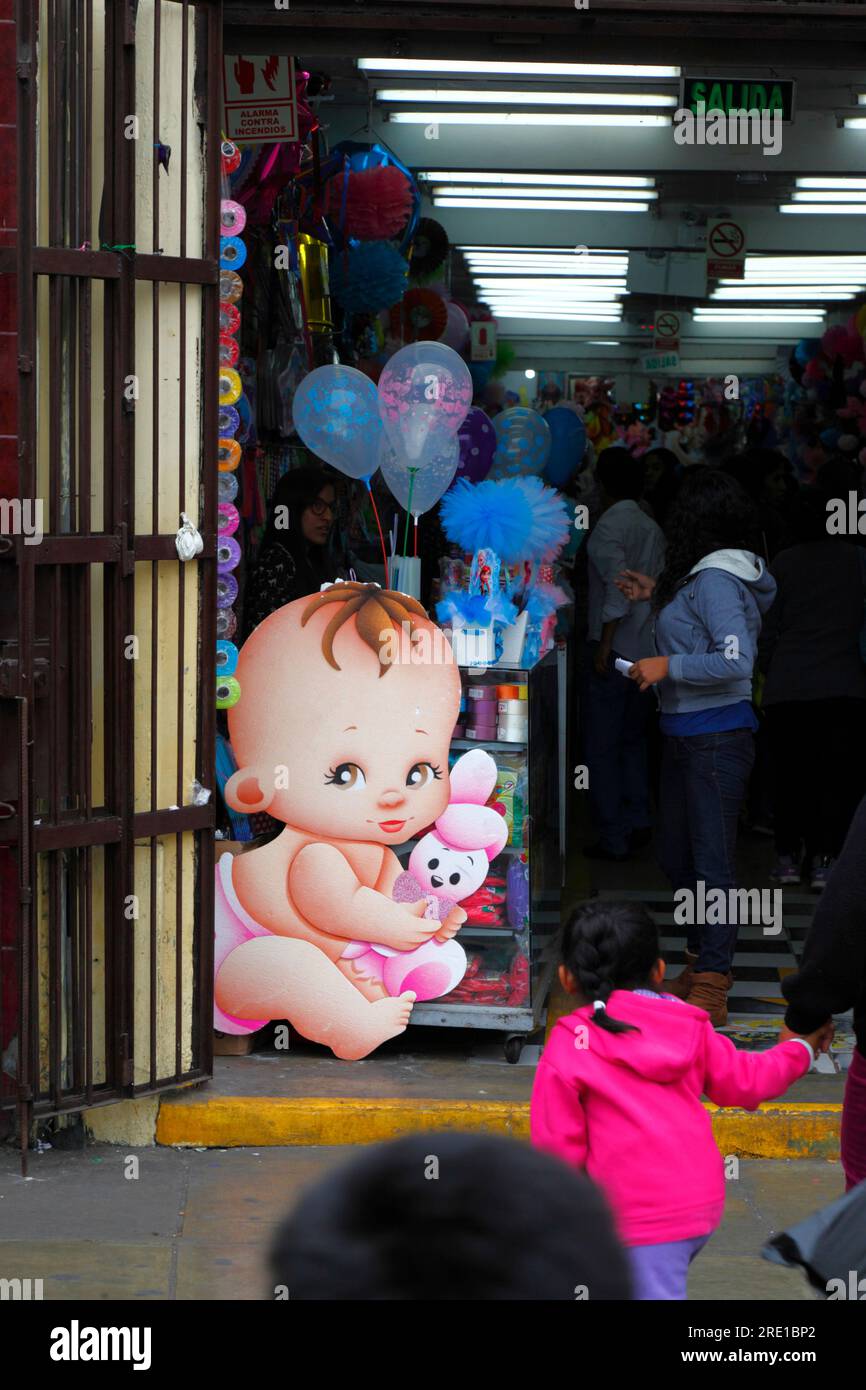 Large cardboard cutout baby in entrance of shop selling things for children in commercial area of central Lima, Peru Stock Photo