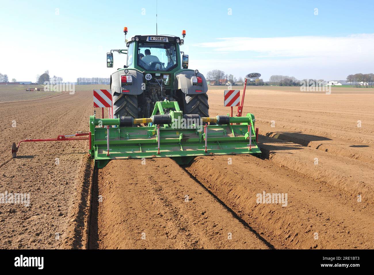 Potato planting, mechanized sowing with tractor and passage of the ditching ridger which prepares 2 ridges, raised ground, for 4 rows. Stock Photo