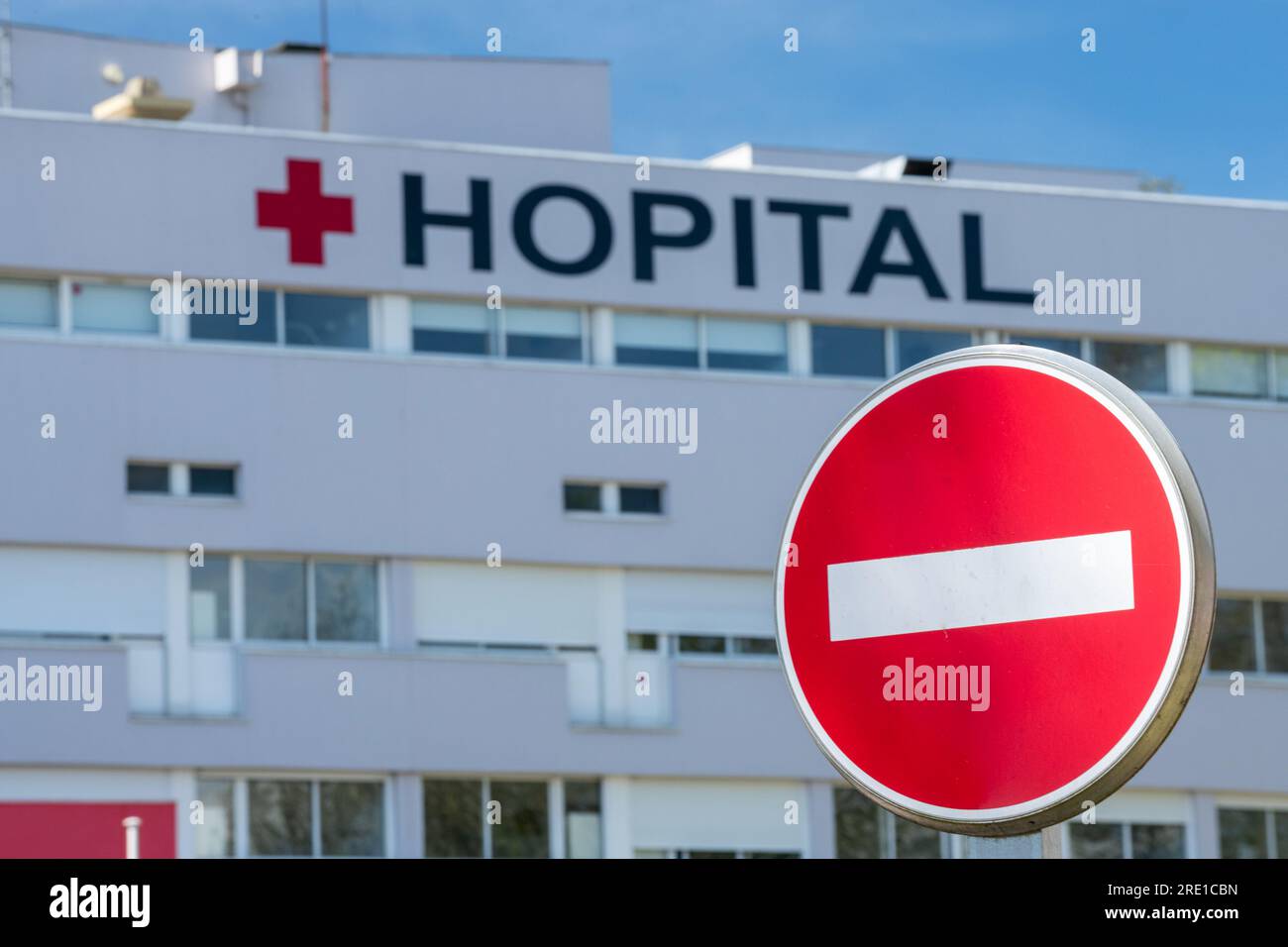 Bois Guillaume (Normandy, northern France):facade of public hospital with Red Cross symbol and one way sign. out of focus, blurred, blurry, fuzzy; cle Stock Photo