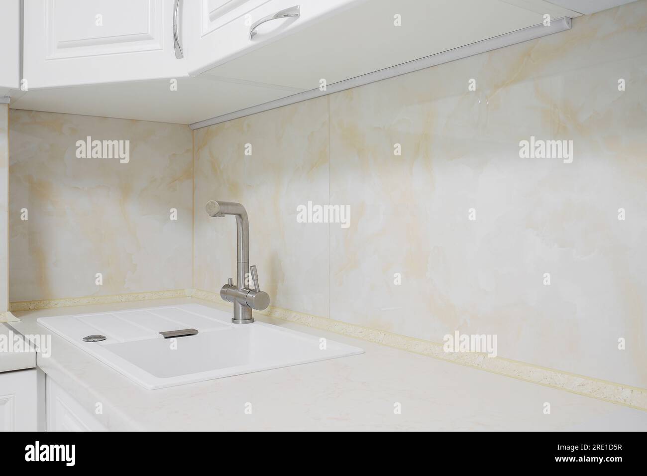 Faucet with white granite sink in the kitchen Stock Photo Alamy