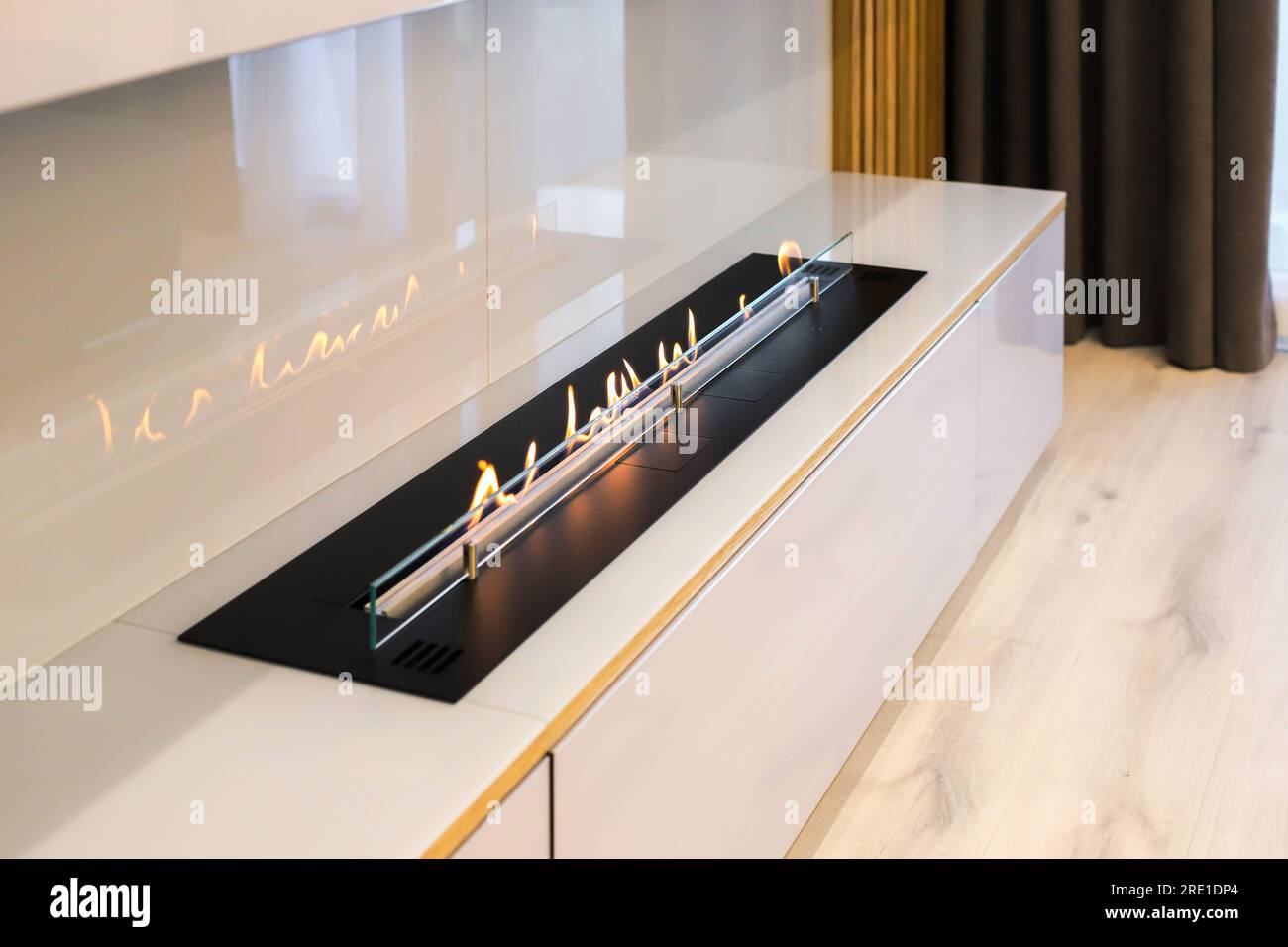 Burning modern eco bio ethanol fireplace built into furniture Stock ...