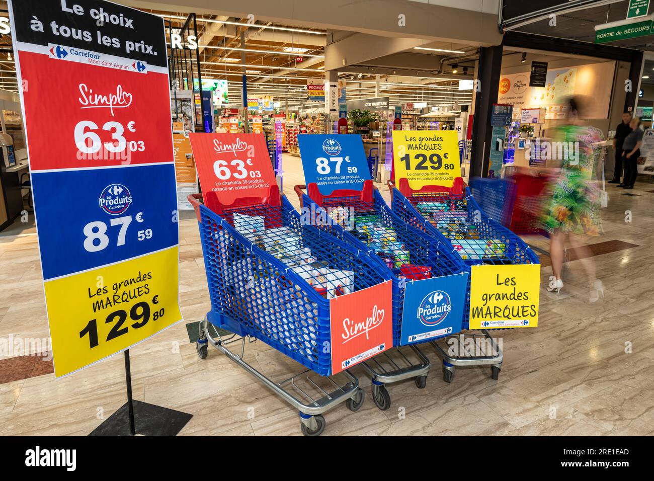 Carrefour hypermarket in Mont Saint Aignan (northern France): price comparison with three shopping carts filled with a range of products, the cheapest Stock Photo