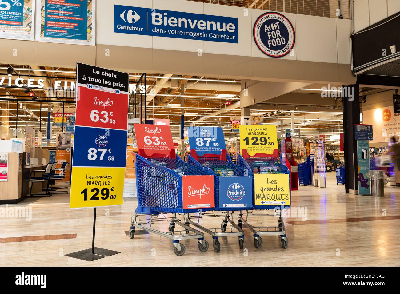 Carrefour hypermarket in Mont Saint Aignan (northern France): price comparison with three shopping carts filled with a range of products, the cheapest Stock Photo