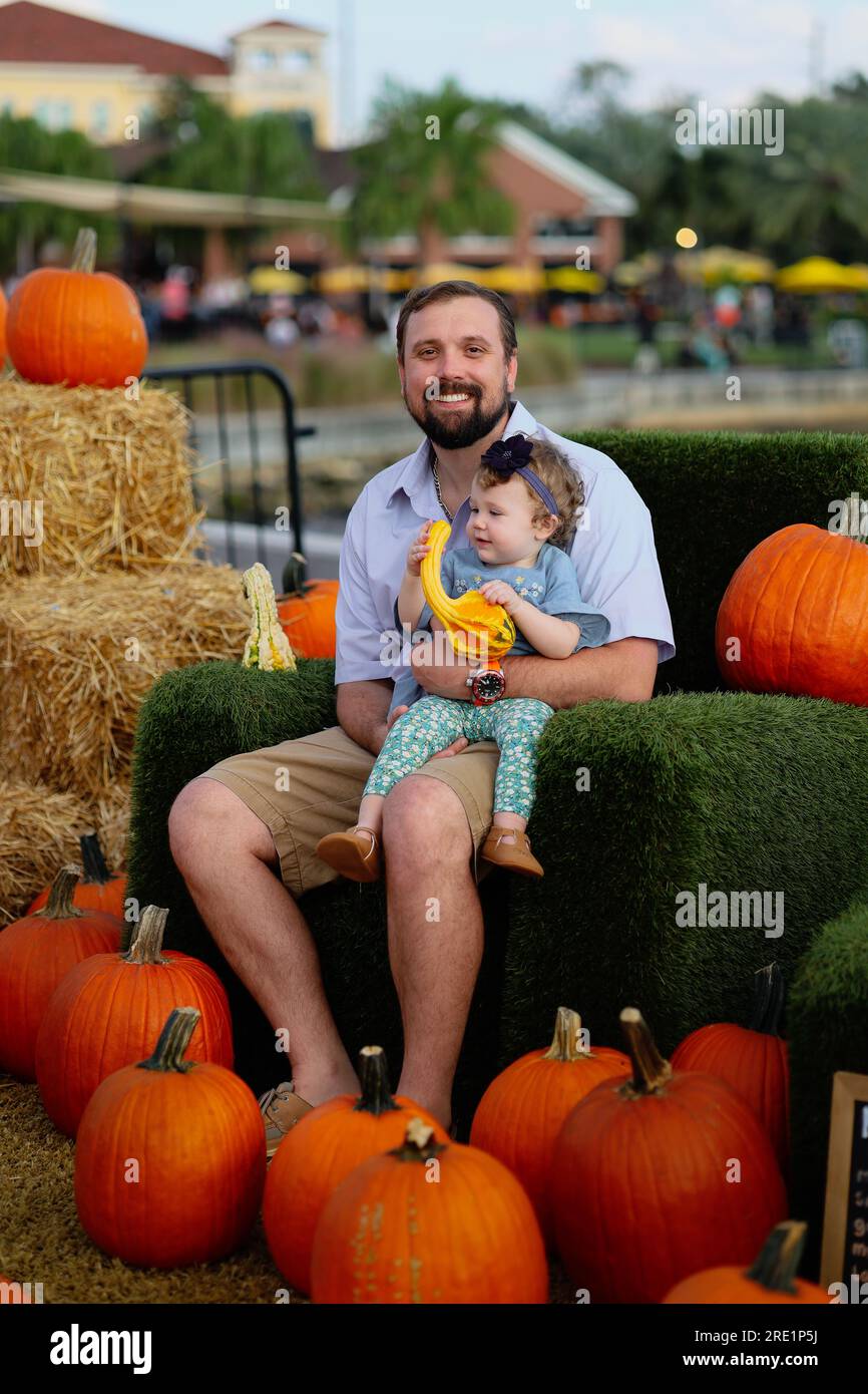 Happy Halloween - smiling dad and little daughter on the background of orange pumpkins on holiday Stock Photo