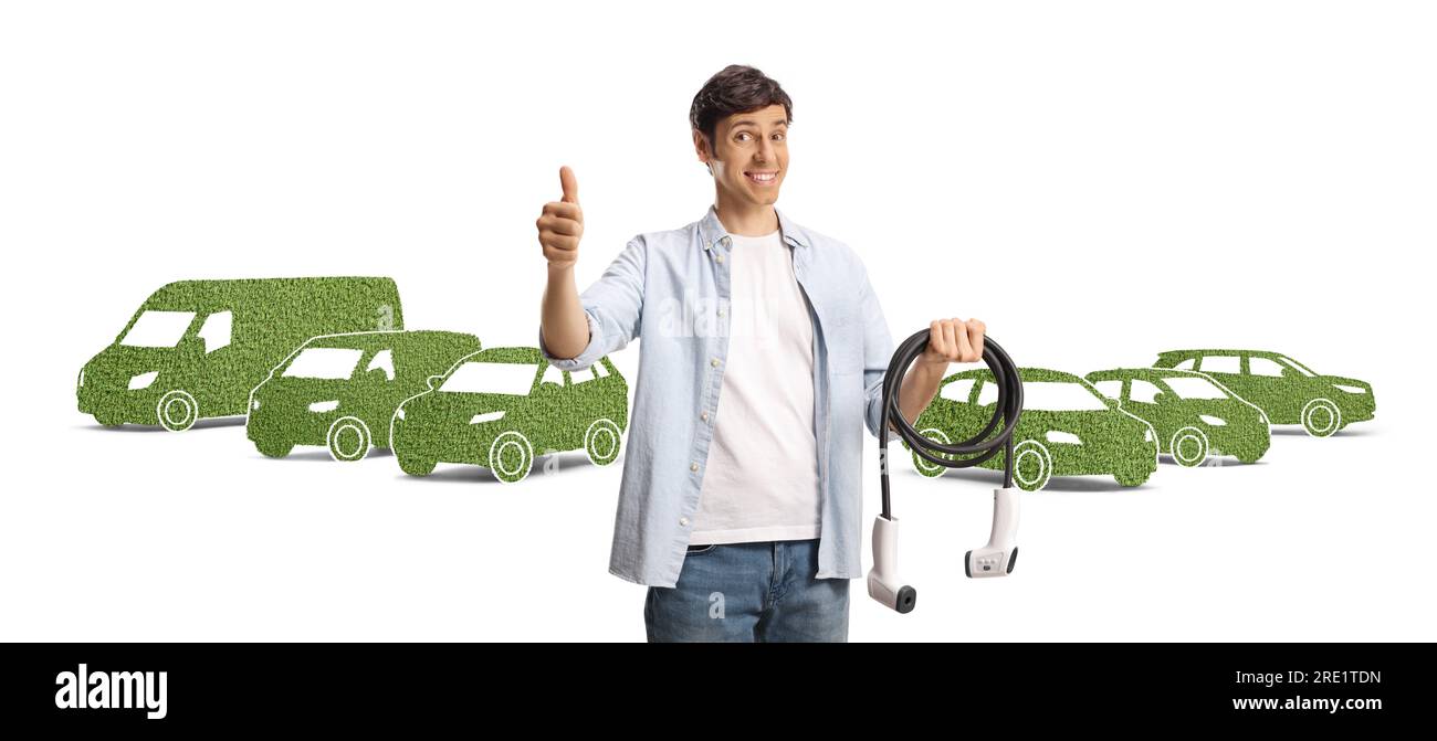 Man holding a cable for ev charging and gesturing thumbs up in front of green vehicles isolated on white background Stock Photo