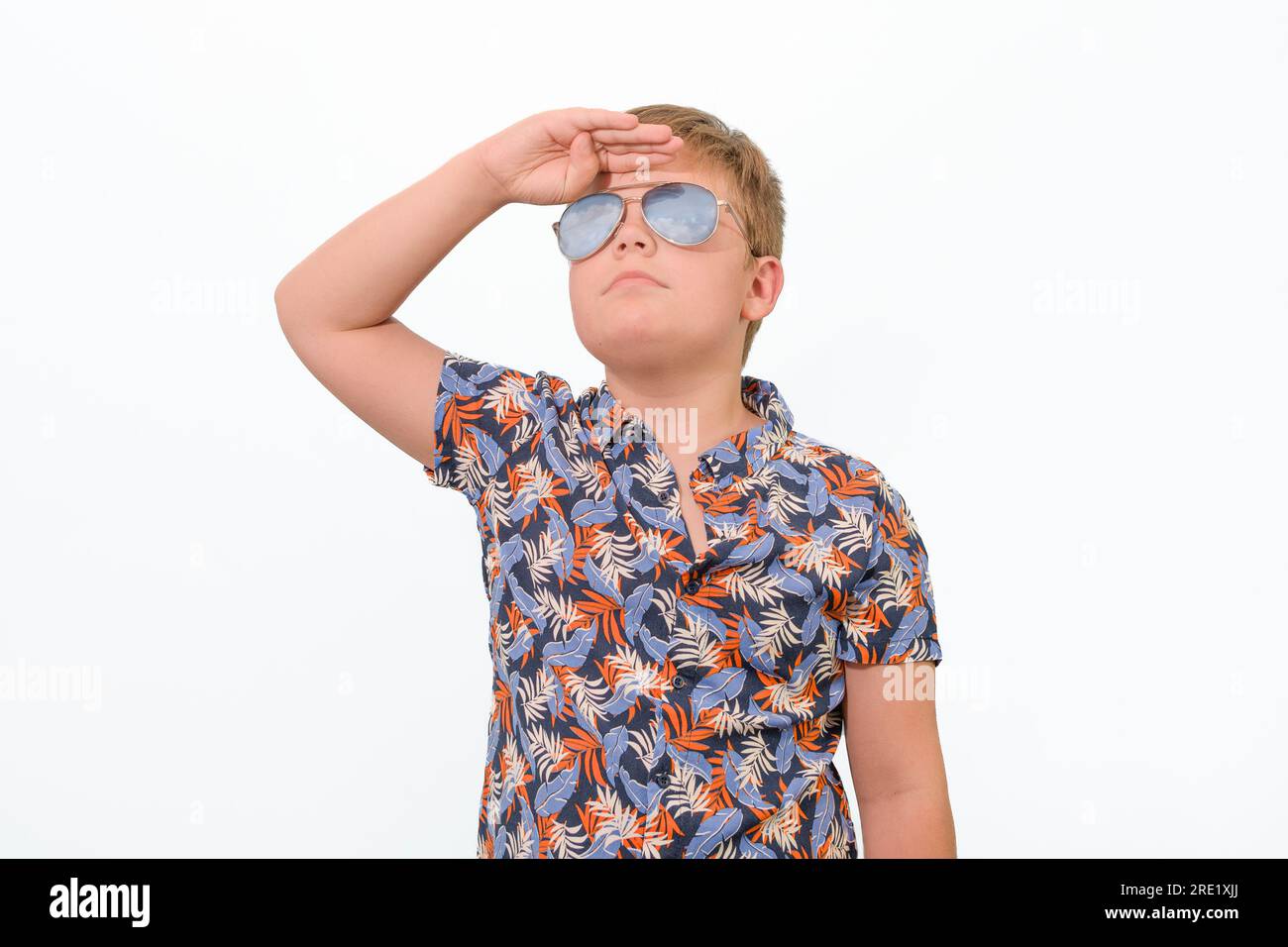 A boy in sunglasses pilot looks intently into the sky. On a white background isolated Stock Photo