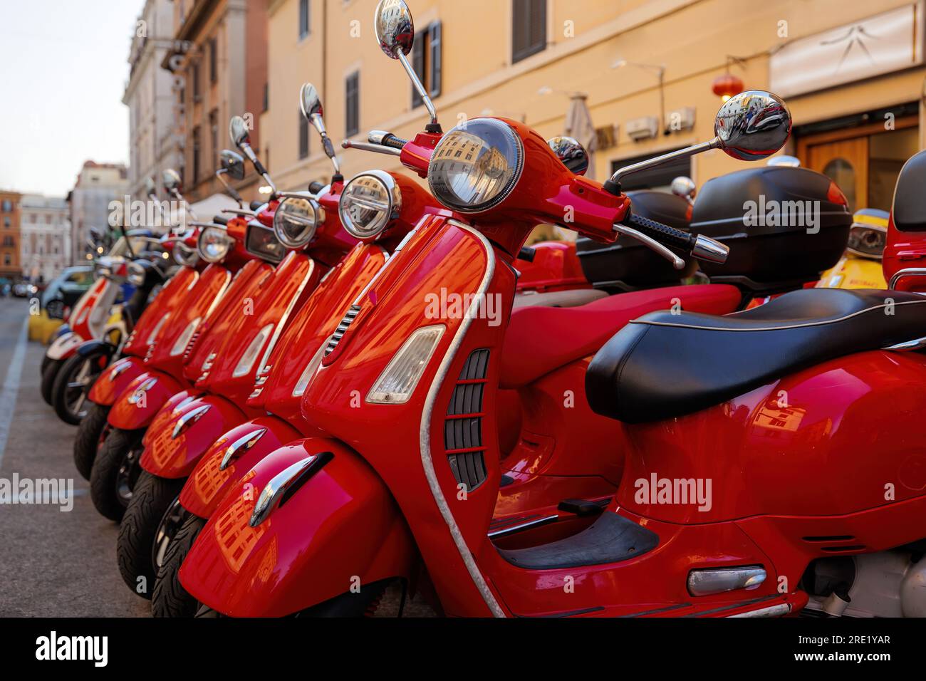 Red colored scooters parked. Scooter rental in town Stock Photo Alamy