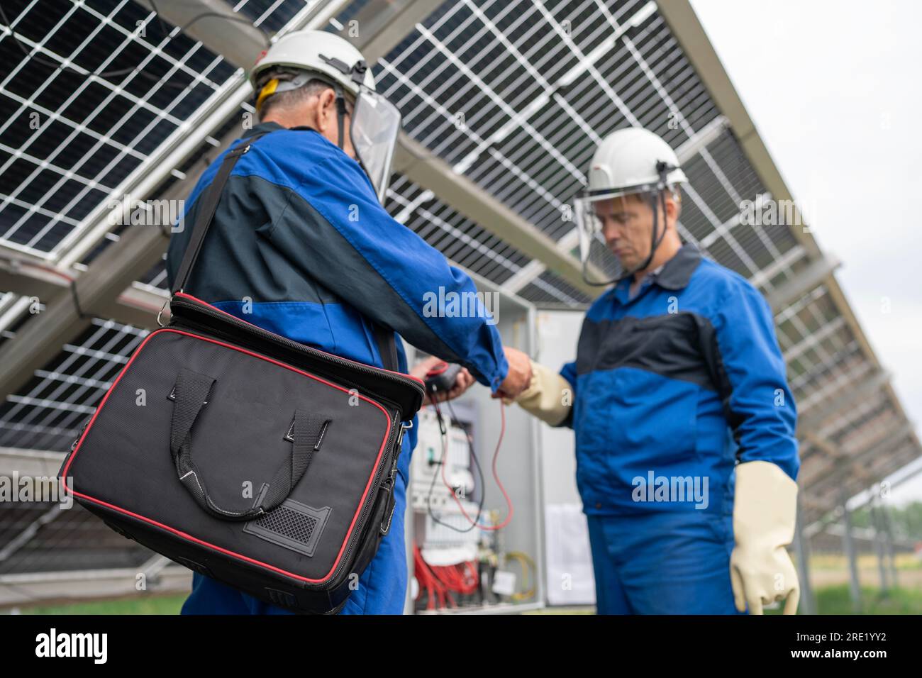Two Service Engineers or electrician working on checking transformer site and solving problem for green energy solar power plant operation. Technician Stock Photo