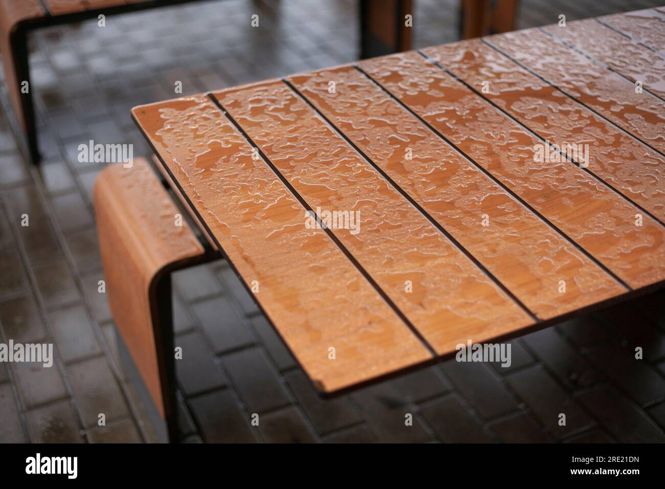 Wet table. Rain outside. Place to eat. Water on table. Stock Photo