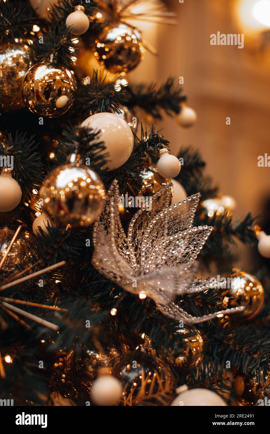 Christmas tree decorated with golden festive Christmas balls and crystal snowflake decoration. Holiday wallpaper with magic bokeh lights.New year wint Stock Photo