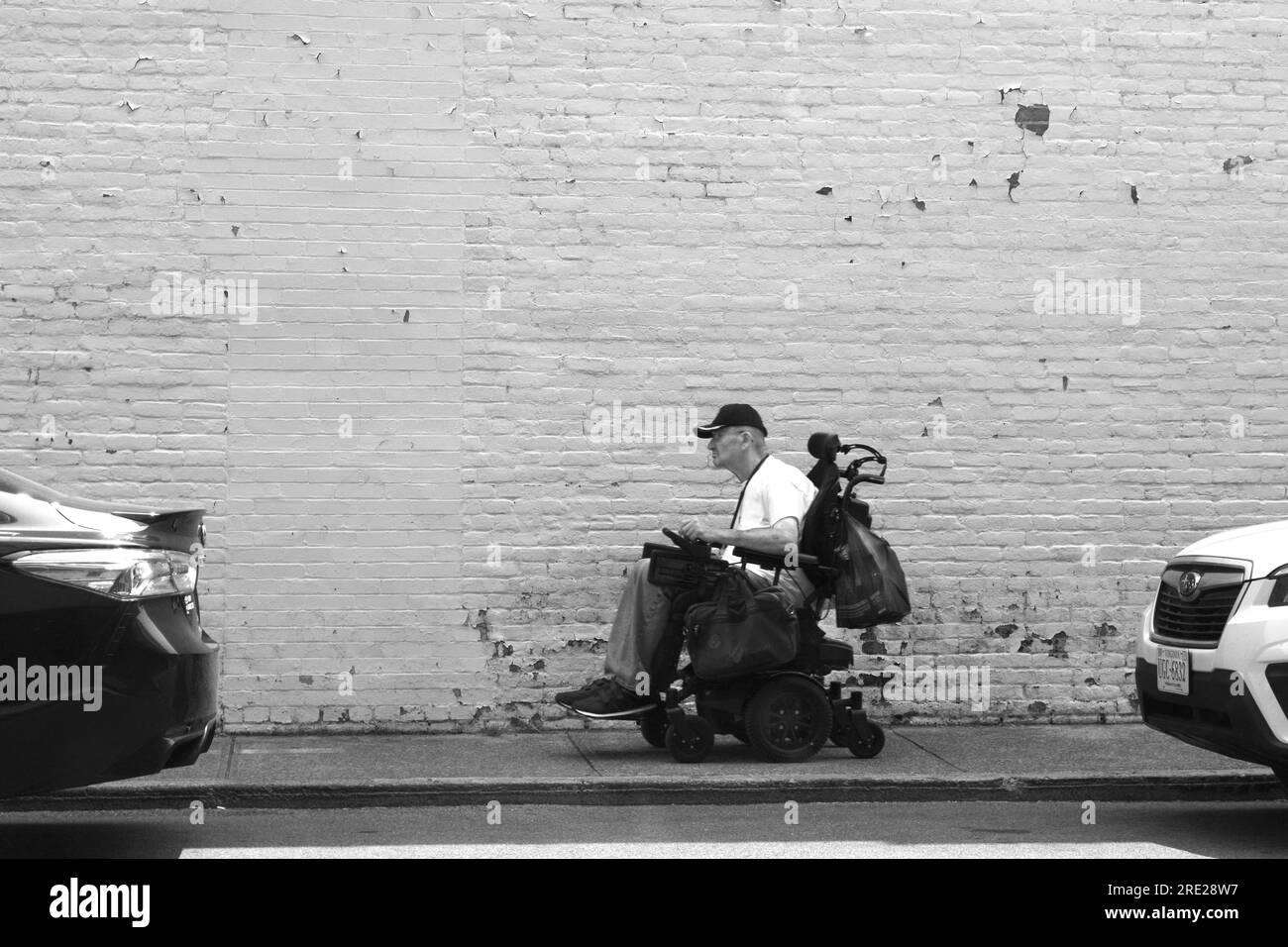 A man rides a battery powered electric power chair or wheelchair along