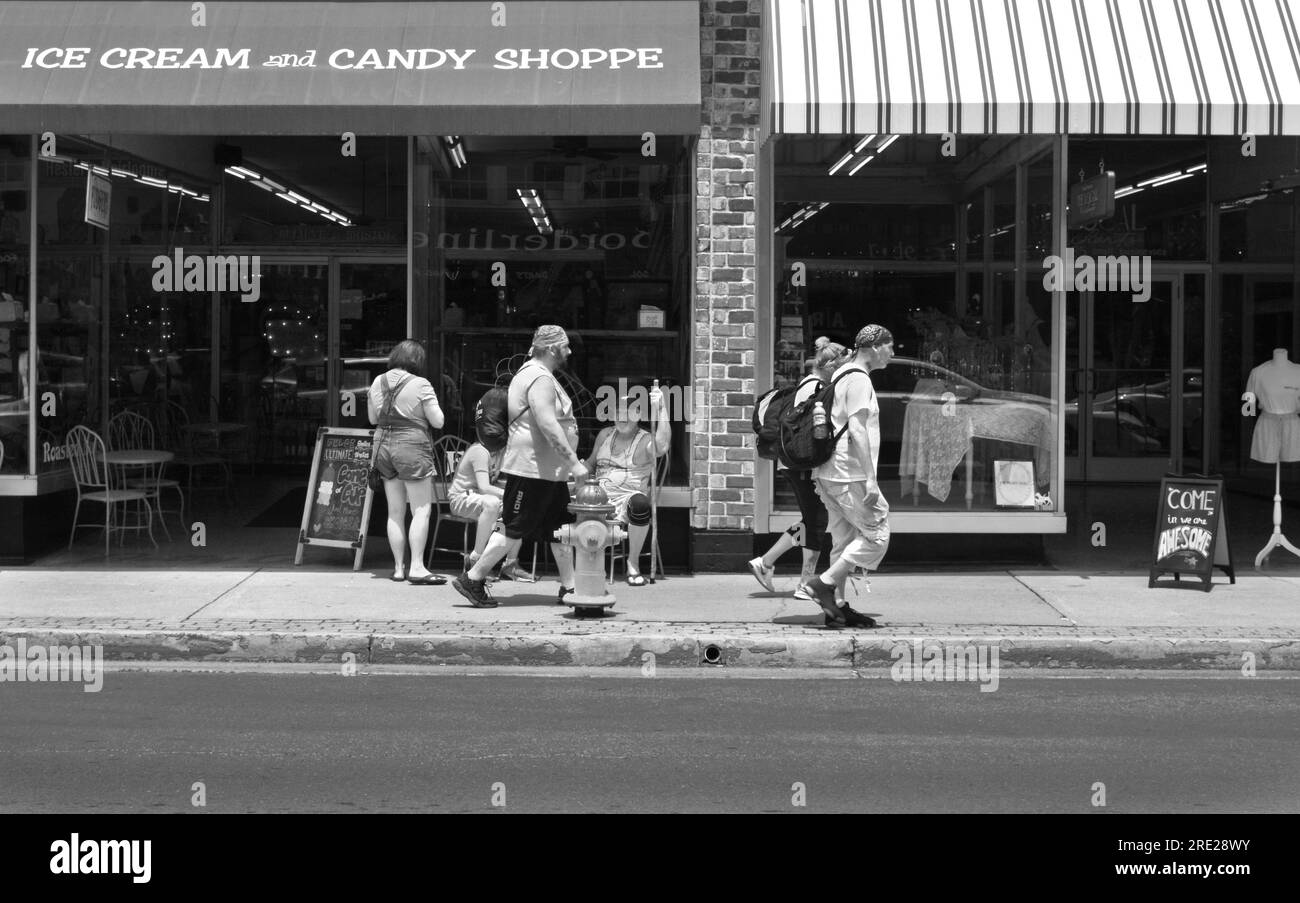 Customer relax at outdoor tables in front of an ice cream shop in