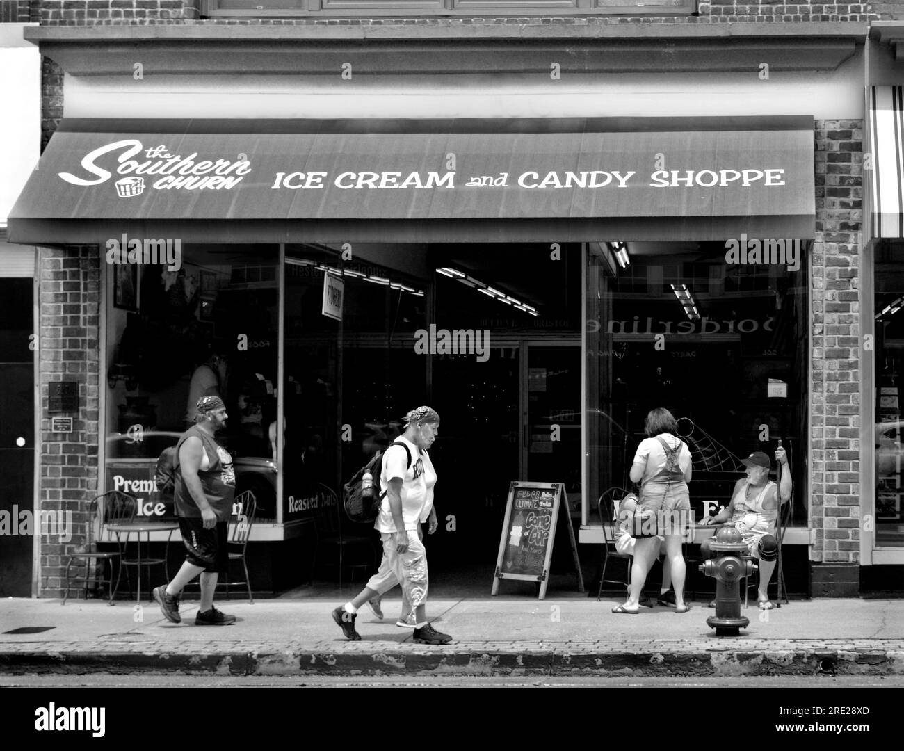 Customer relax at outdoor tables in front of an ice cream shop in