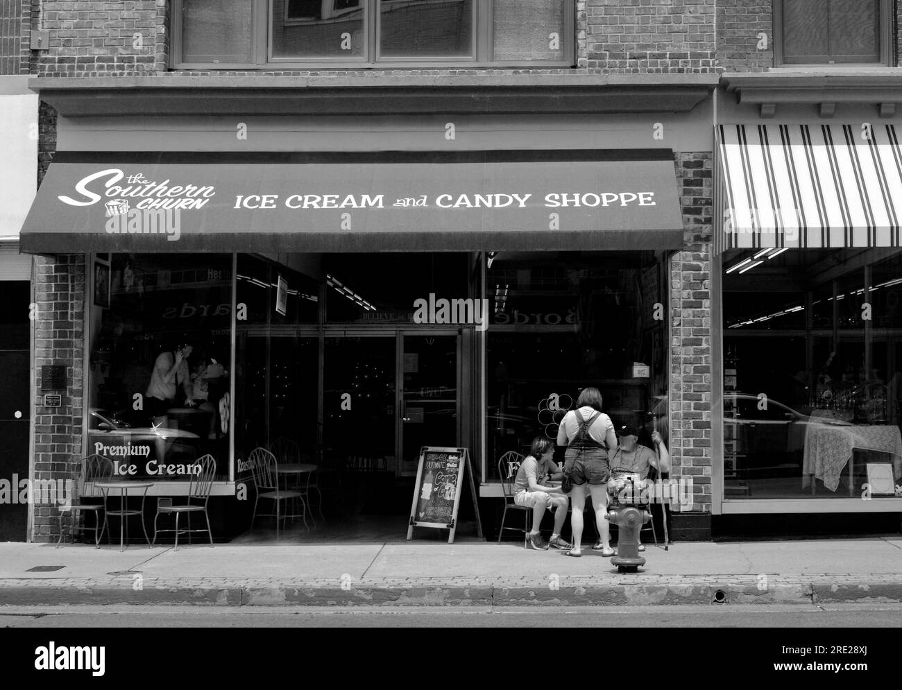 Customer relax at outdoor tables in front of an ice cream shop in