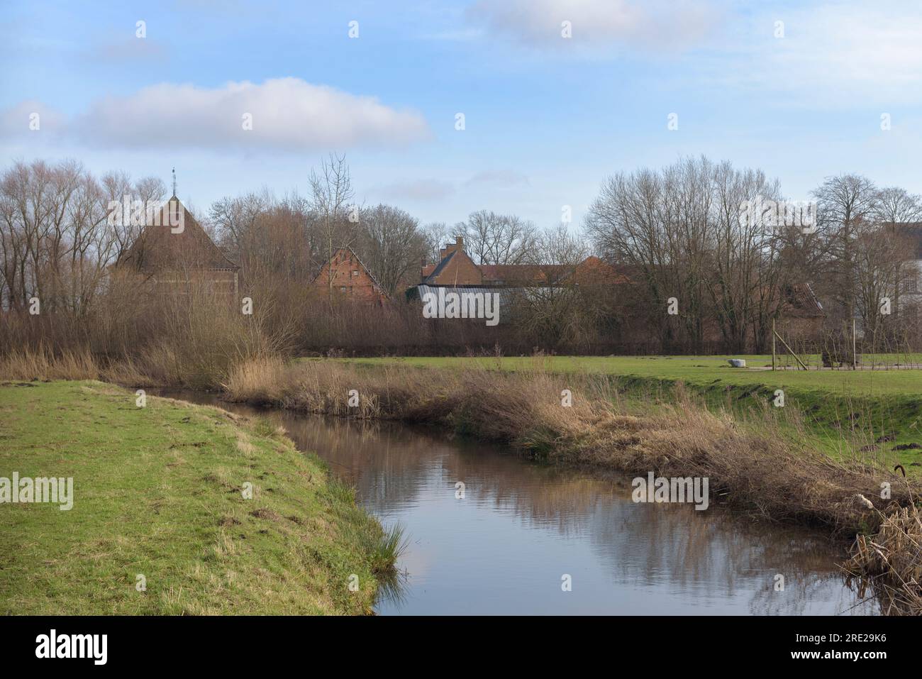 Modern European spring rural landscape. A small river, houses and a ...