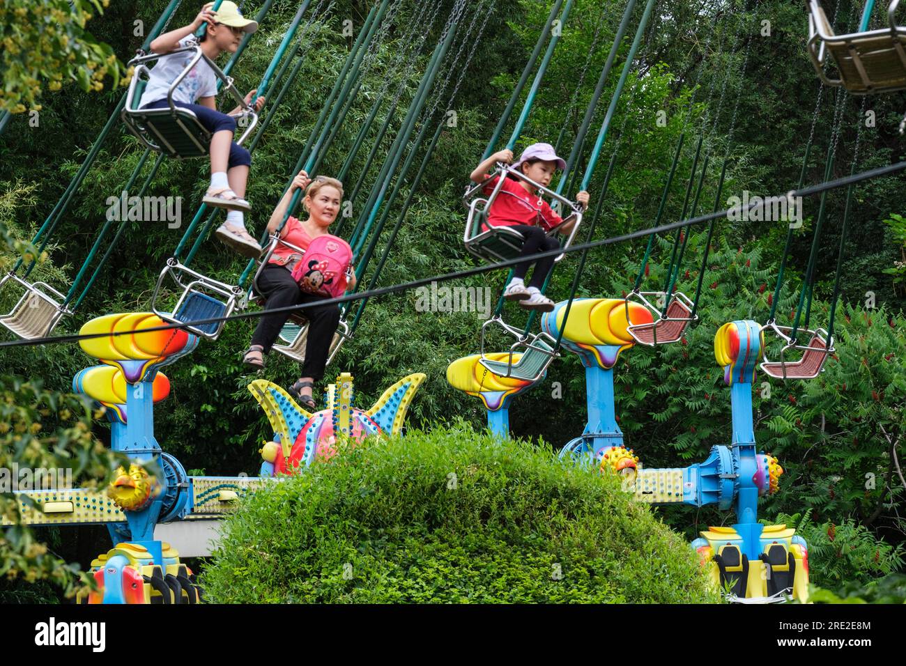 Kazakhstan, Almaty. People on Amusement Park Ride, Central Park for Culture and Recreation. Stock Photo