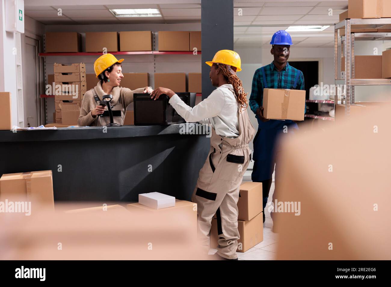 Smiling storehouse operators chatting at reception desk doing inventory ...