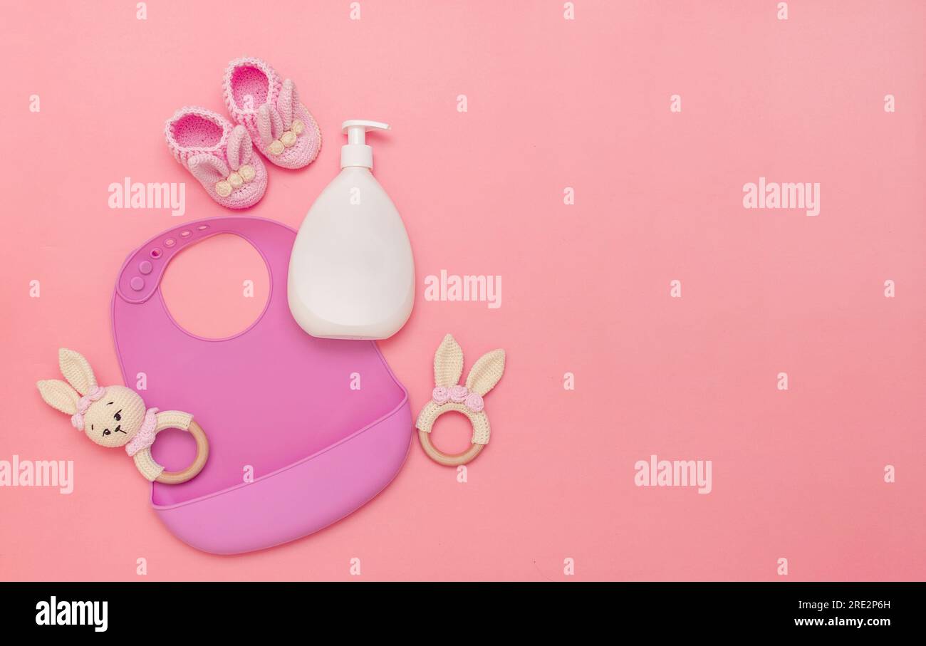 Bib and wooden toys on pink background. Baby shower concept. Fancy
