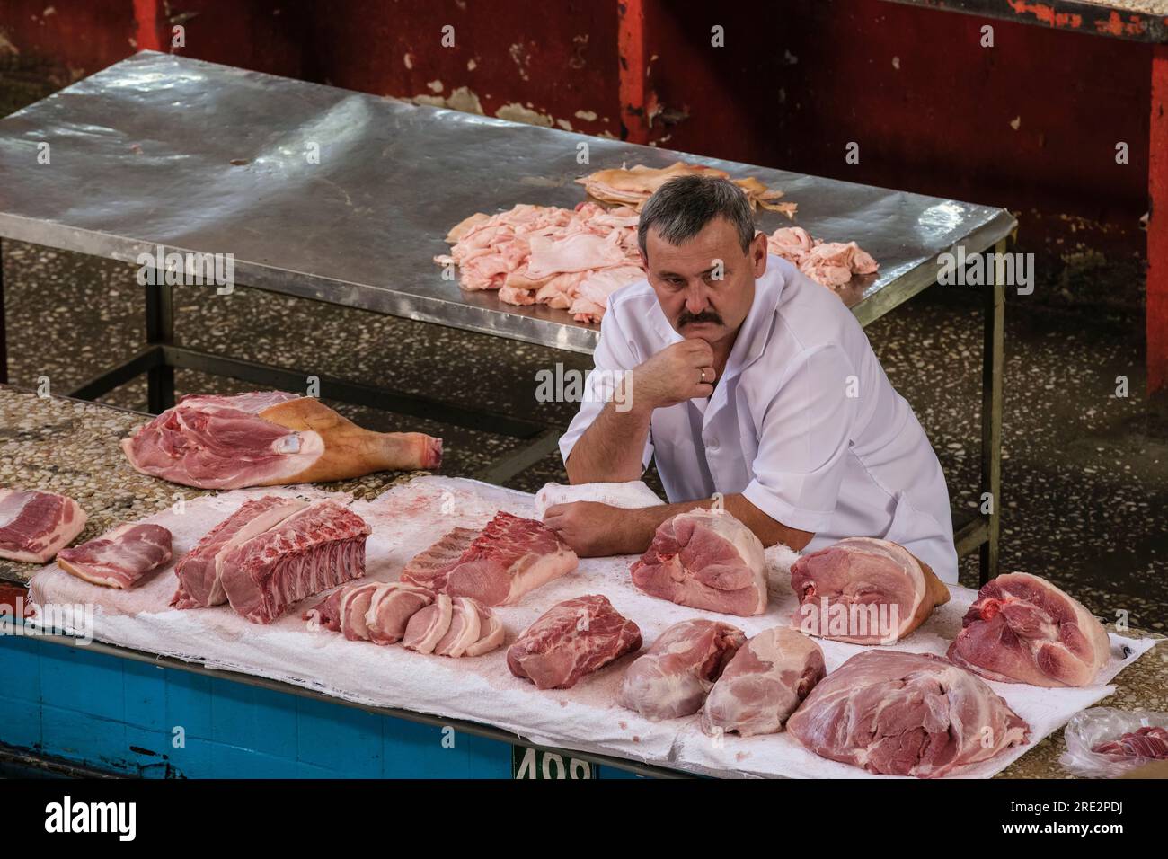 Kazakhstan, Almaty. Butcher in the Green Bazaar Waiting for a Customer. Stock Photo