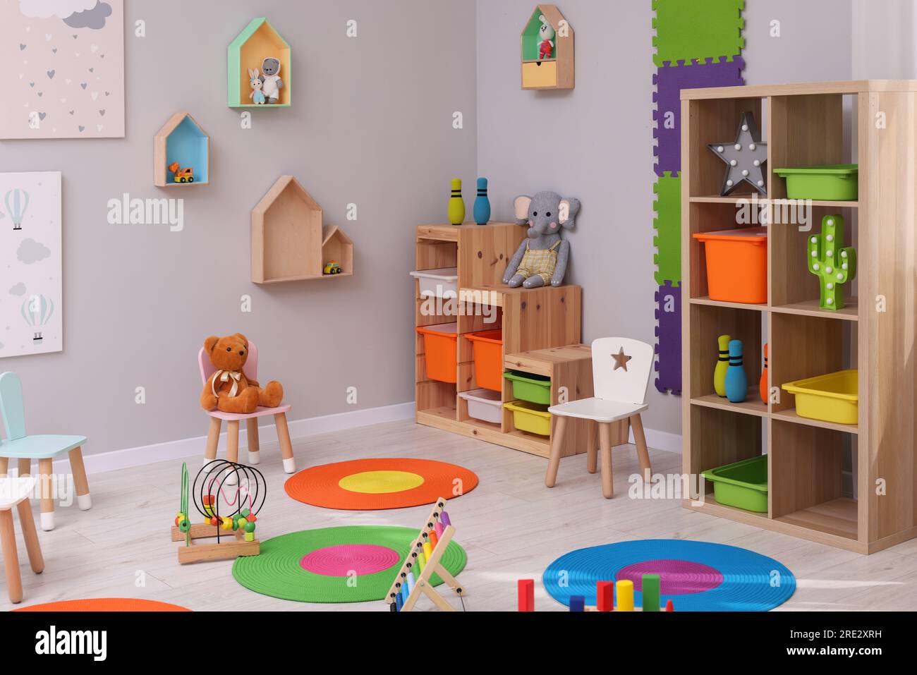Child`s playroom with different toys and furniture. Cozy kindergarten ...