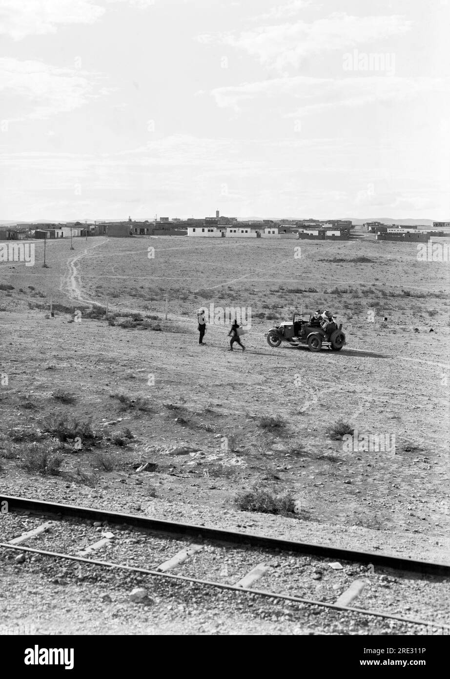 Zarqa, Jordan  November, 1930 The modern town of Zarqa with telephone lines, railroad tracks, and an automobile with people in the rumble seat. Stock Photo