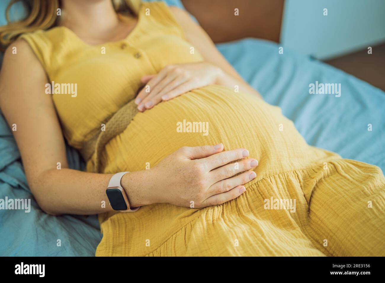 A stressed tired pregnant mother lying in bed at home. Morning sickness