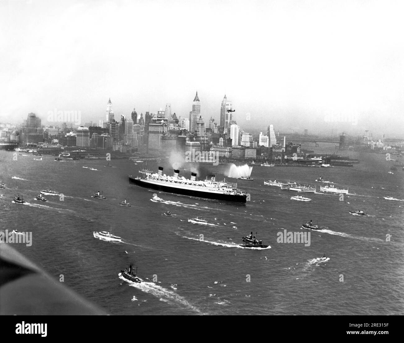 New York, New York:  June 1, 1936 The S.S. Queen Mary steams up NY harbor with a flotilla of escorts after making her maiden voyage across the Atlantic Ocean. Stock Photo