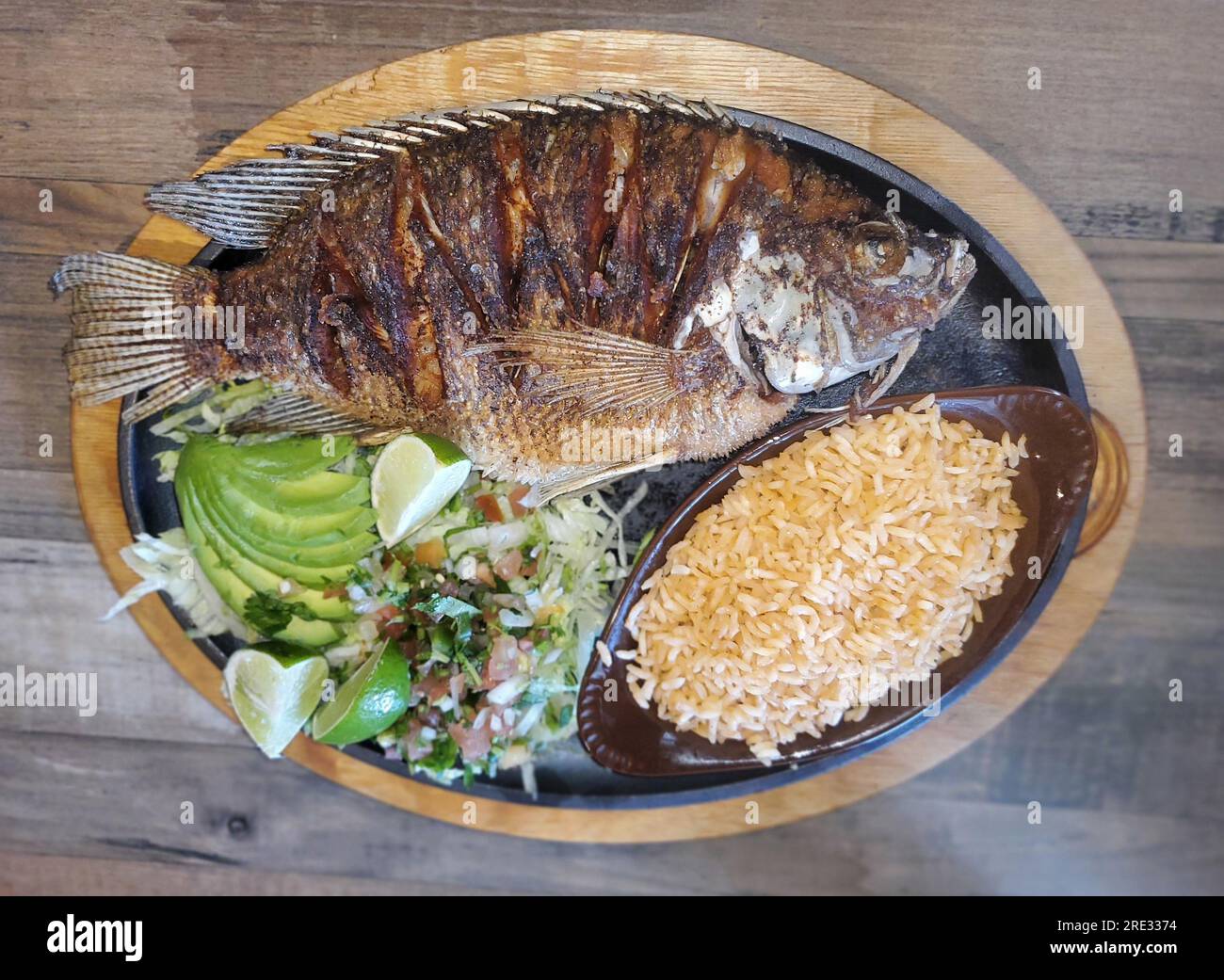 Pescado Frito, a Mexican dish with fried tilapia, yellow rice, salad