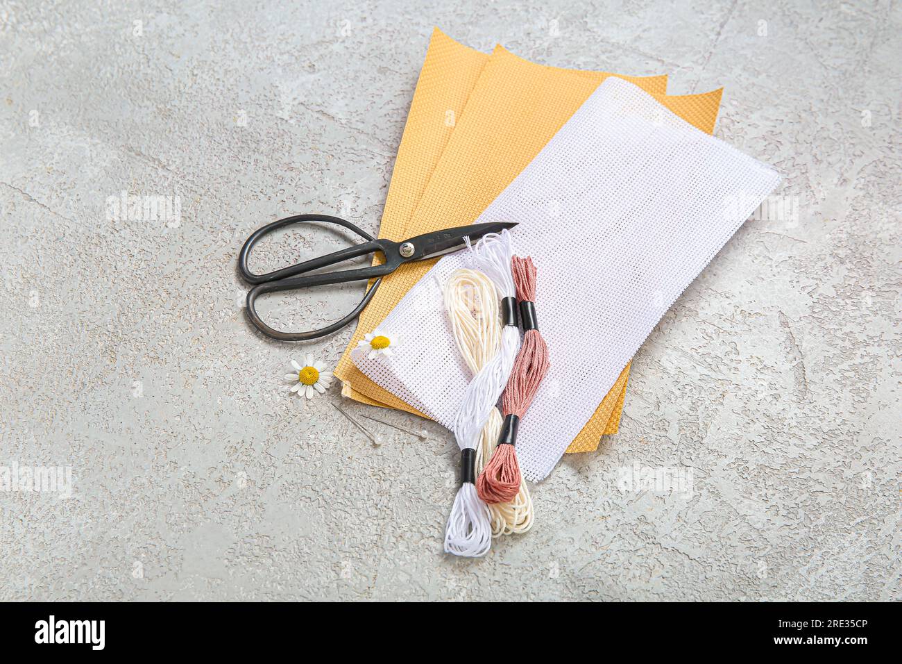 Canvases with scissors and mouline threads on grunge grey background ...