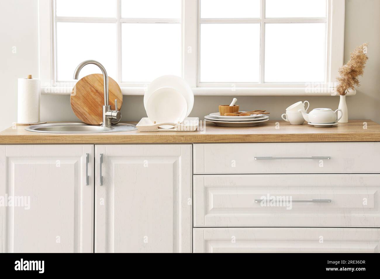 Kitchen counter with sink, plate rack and clean dishes near window Stock Photo Alamy