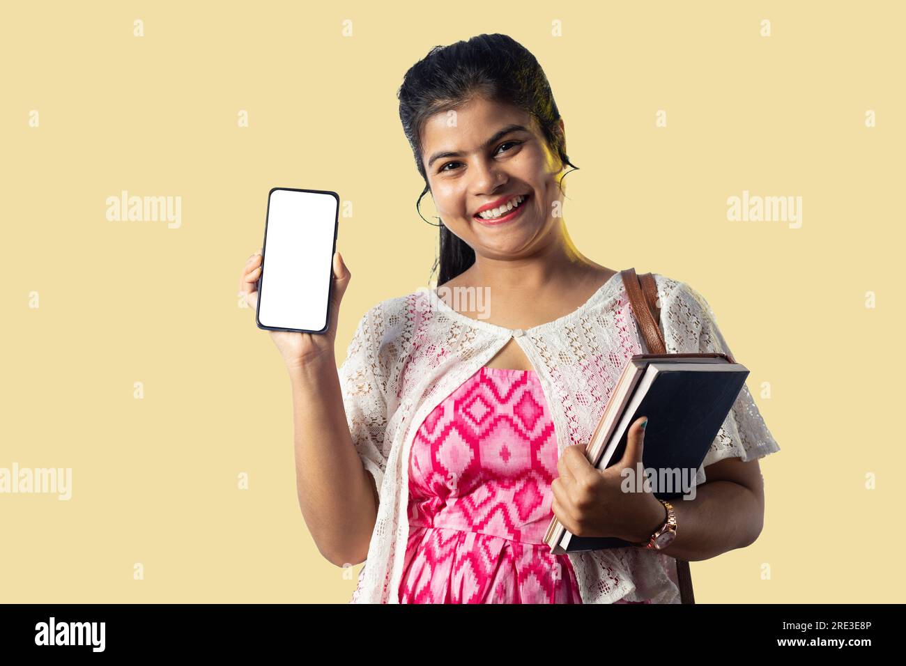 A pretty young Indian girl with books showing blank white screen of ...