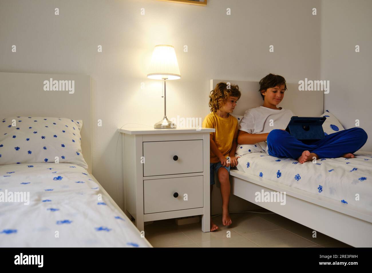 Brothers using tablet in bedroom Stock Photo